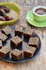 Dates tahini square sweet bites topped with sesame seeds. Served with espresso coffee.
