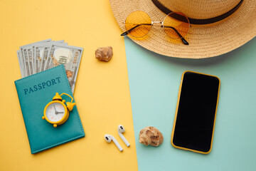 Travel accessories and passport with money on blue yellow background.