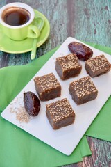 Dates tahini square sweet bites topped with sesame seeds. Served with espresso coffee.
