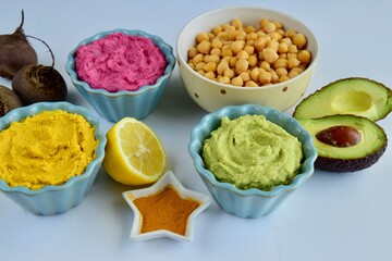 Assorted colorful hummus, healthy vegan dips. Traditional Middle eastern. Avocado hummus, Beetroot hummus, Turmeric hummus