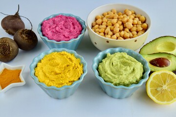 Assorted colorful hummus, healthy vegan dips. Traditional Middle eastern. Avocado hummus, Beetroot hummus, Turmeric hummus