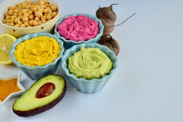 Assorted colorful hummus, healthy vegan dips. Traditional Middle eastern. Avocado hummus, Beetroot hummus, Turmeric hummus