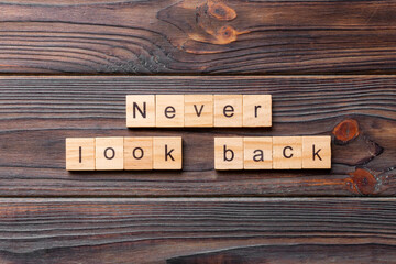 never look back word written on wood block. never look back text on wooden table for your desing, concept