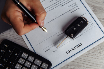 Close up shots hands of client signing car lease form. Top view.