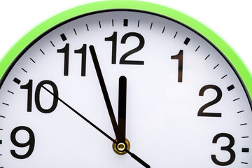 Part of the clock with time three minutes to twelve o'clock. White background.