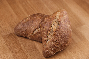 Zwei frische knusprige Frühstücksbrötchen auf einem Holzbrettchen