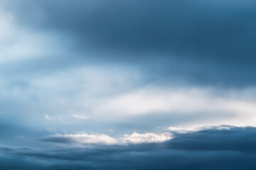 Moody blue sky with clouds and sun light shining through  for wallpaper
