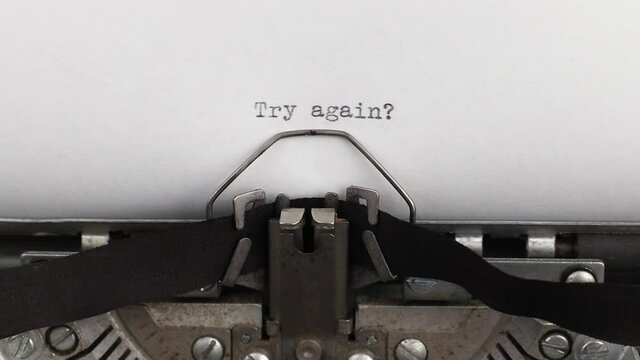 to type motivational quote try again on a vintage and old typewriter close-up