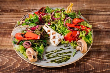 Salad with cheese, mushrooms and vegetables on wooden background