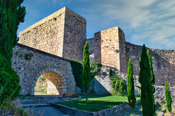 Jardin, puente de piedra y castillo de Cuenca con su puerta en arco de Bezudo del siglo XVI