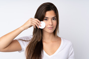 Teenager girl over isolated background with cotton pad for removing makeup from her face