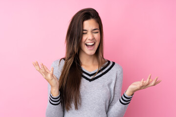 Teenager girl over isolated pink background unhappy and frustrated with something