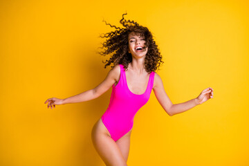 Fototapeta na wymiar Photo of attractive overjoyed lady sun rays skin exotic resort eyes closed wavy hairdo flight air breeze relax rest tourist wear pink swimsuit isolated bright vivid yellow color background