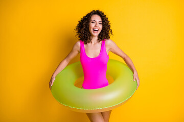 Photo of pretty attractive funny overjoyed lady relax rest exotic resort prepare swim big round circle seaside ocean shore hot water wear pink swimsuit isolated vivid yellow color background