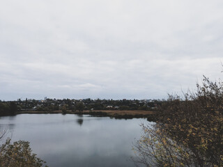 The tops of autumn trees near the lake. Overcast weather