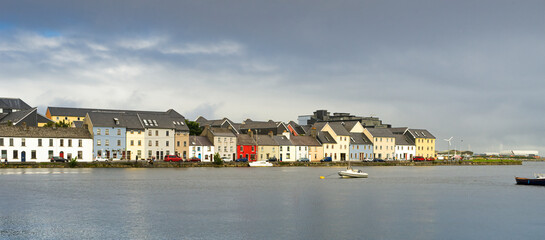 Fototapeta na wymiar Panoramic view of colored houses in Galway Bay on a cloudy day.