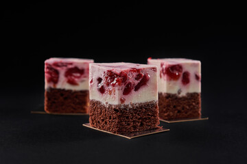 Brown biscuit and pink mousse cake slices.