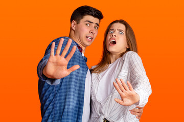 Obraz premium Shock, disgust and horror. Frightened young man and lady nervous fenced off with hands