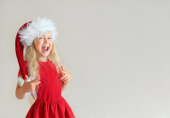 Funny laughing blonde girl in the Santa hat
