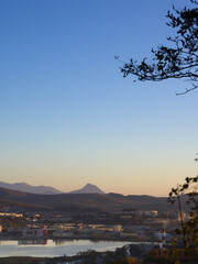 Landscape with mountain ridge and lake among city.