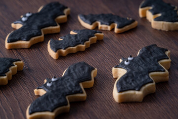 Close up of decorating cute Halloween bat sugar cookies with frosting.