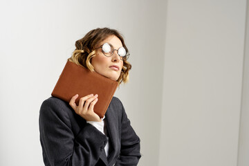 business woman in a suit with documents in hands light background curly hair hairstyle