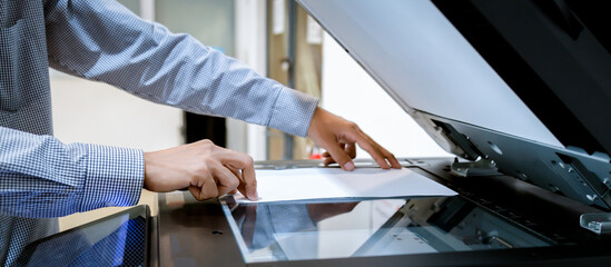 Business man Hand press button on panel of printer, printer scanner laser office copy machine supplies start - obrazy, fototapety, plakaty