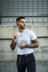 Chico joven tatuado posando de manera natural
