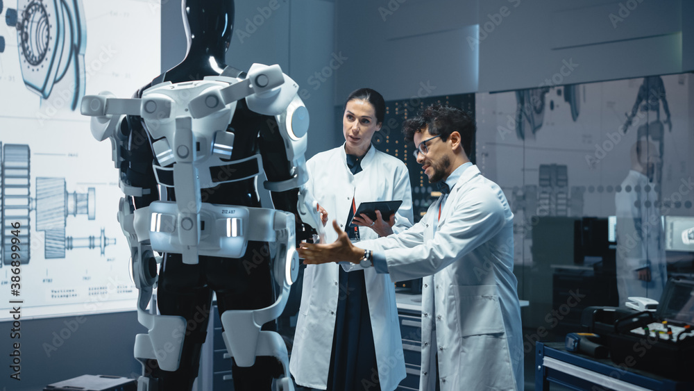 Poster In Robotics Development Laboratory: Chief Female Engineer and Top Male Scientist Work on a Bionics Exoskeleton Prototype. Designing Powered Exosuit to Help Disabled People, Hard Labor Workers