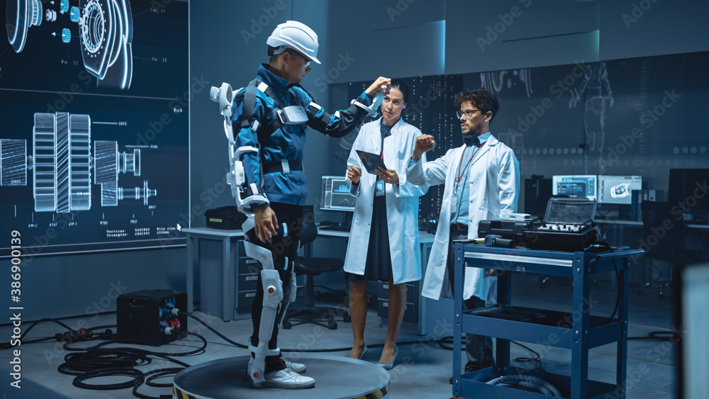 Leinwandbilder In Robotics Development Laboratory: Engineers and Scientists Work on a Bionics Exoskeleton Prototype with Person Testing it. Designing Wearable Exosuit to Help Disabled People, Warehouse Workers