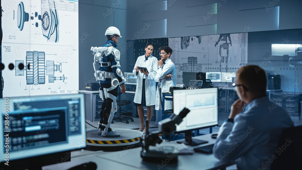 Leinwandbilder In Robotics Development Laboratory: Engineers and Scientists Work on a Bionics Exoskeleton Prototype with Person Testing it. Designing Wearable Exosuit to Help Disabled People, Warehouse Workers