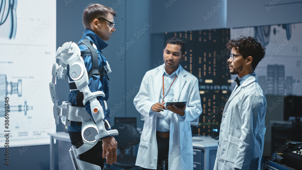 Leinwandbilder In Robotics Development Laboratory: Engineers and Scientists Work on a Bionics Exoskeleton Prototype with Person Testing it. Designing Wearable Exosuit to Help Disabled People, Warehouse Workers