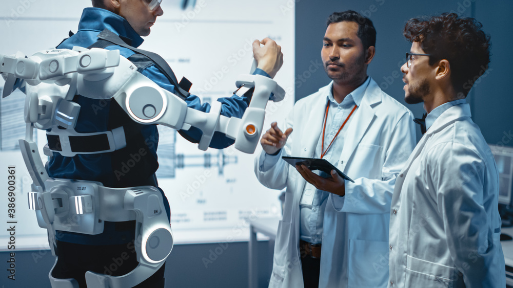 Leinwandbilder In Robotics Development Laboratory: Engineers and Scientists Work on a Bionics Exoskeleton Prototype with Person Testing it. Designing Wearable Exosuit to Help Disabled People.