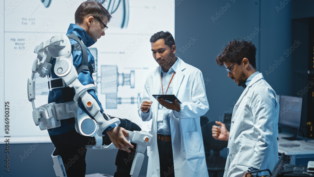 Leinwandbilder In Robotics Development Laboratory: Engineers and Scientists Work on a Bionics Exoskeleton Prototype with Person Testing it. Designing Wearable Exosuit to Help Disabled People, Warehouse Workers