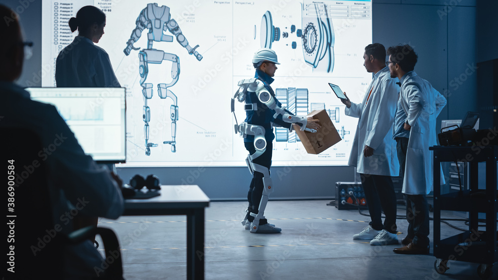 Leinwandbilder in development laboratory: engineers look at robotics exoskeleton prototype presentation with person