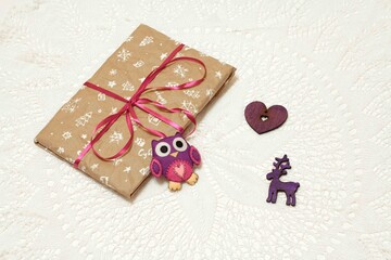 Photo of a New Year's gift in craft packaging with a felt toy owl.