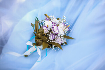 Beautiful wedding bouquet of fresh eustomas and chrysanthemums on a blue tulle background