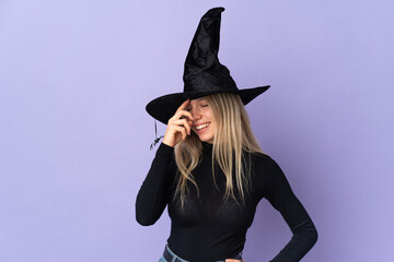 Young woman with witch costume over isolated background laughing