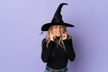 Young woman with witch costume over isolated background frustrated and covering ears