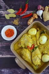 Opor ayam, chicken cooked in coconut milk from Indonesia, from Central Java, added with boiled eggs, served with lontong and sambal. Popular dish for lebaran or Eid al-Fitr