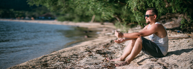 The guy is resting on the lake at sunset
