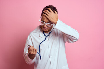 young doctor with a stethoscope and glasses on a pink background nurse interns model