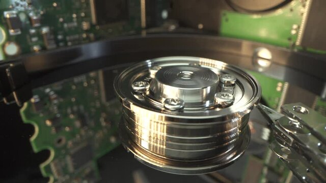Electronics repair. Microship of Hard Drive disk in Macro shot. Electronics and computer technology. Chip and hot air. Work in the service center. Spindle, disk and ribbon in close up. HDD. Many