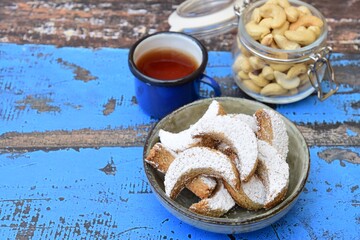 kue Putri salju (snow princess cookies or snow white cookies) is cute crescent shaped vanilla cookie with a crumbly, melt-in-your-mouth texture and covered in powdered sugar. served with tea
