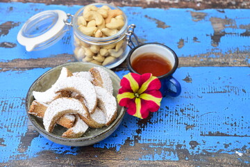 kue Putri salju (snow princess cookies or snow white cookies) is cute crescent shaped vanilla cookie with a crumbly, melt-in-your-mouth texture and covered in powdered sugar. served with tea
