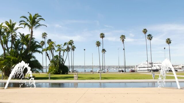 Fountain in waterfront city park near San Diego county civic center in downtown, California government authority, USA. Pacific ocean harbour, embarcadero in Gaslamp Quarter. Palms and grass near pier.