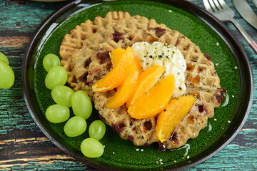 Gluten Free Quinoa Dark Chocolate Waffles Served with Green Grapes, Orange, Coconut Yoghurt, Maple Syrup and Hemp Seeds