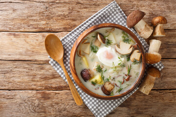 Kulajda is a Traditional Czech white soup full of flavors. This classic recipe contains mushrooms, potatoes, egg and dill close-up in a bowl on the table. Horizontal top view from above