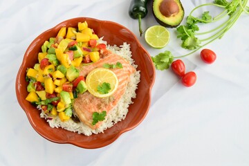 Baked salmon with coconut rice and mango salsa. Top view, white background