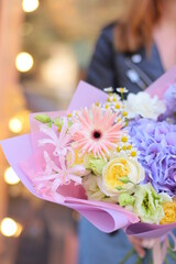 Colorful flowers assorted bouquet in bright paper. Holiday celebration concept. Bouquet of beautiful flowers in hands. Colorful flowers bouquet wrapped in paper